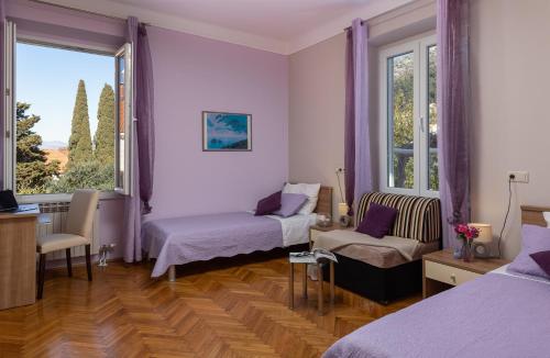 a room with two beds and a couch and a window at Villa Falkoni II in Dubrovnik