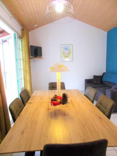 une table en bois avec une lampe et des fruits. dans l'établissement Charming Apt With Balcony And Golf View, à Moliets-et-Maa