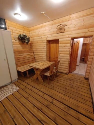 a wooden room with a wooden table and chairs at Tauriņkrasti in Bērzciems