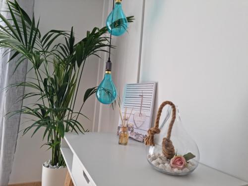 a white table with two plants and two blue lights at APARTAMENTO CORAL in Guía de Isora