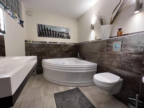 un bagno con vasca, WC e lavandino di Fewo mit Garten, Kamin u. Whirlpool a Berlino