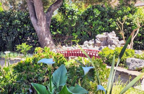 a red bench in a garden with a tree at 628 Madre Street in Pasadena