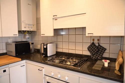 a kitchen with white cabinets and a stove top oven at Montello Apartment a pochi passi dal centro in Noale