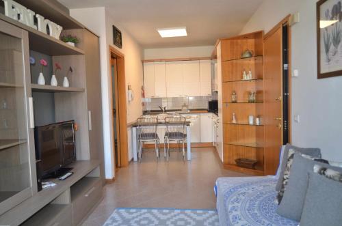 a living room with a couch and a kitchen at Montello Apartment a pochi passi dal centro in Noale