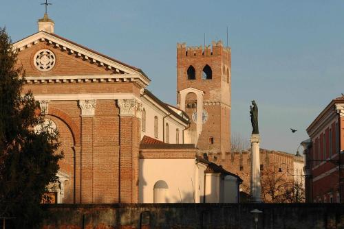 a building with a clock tower and a church at Montello Apartment a pochi passi dal centro in Noale