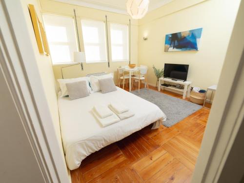 een slaapkamer met een bed met twee handdoeken erop bij Oporto Guest Alegria Flat Downtown in Porto