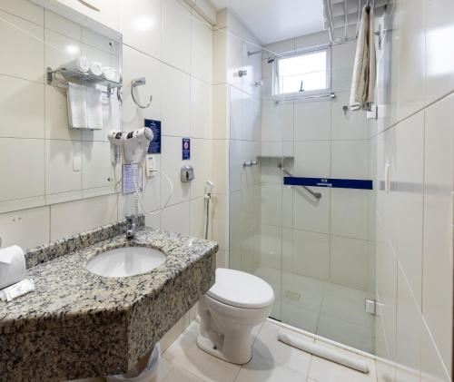 a bathroom with a sink and a toilet and a shower at Centromar Hotel in Balneário Camboriú