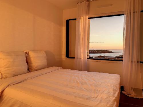 une chambre avec un lit et une grande fenêtre dans l'établissement 2br apartment with parking near Monaco, à Beausoleil