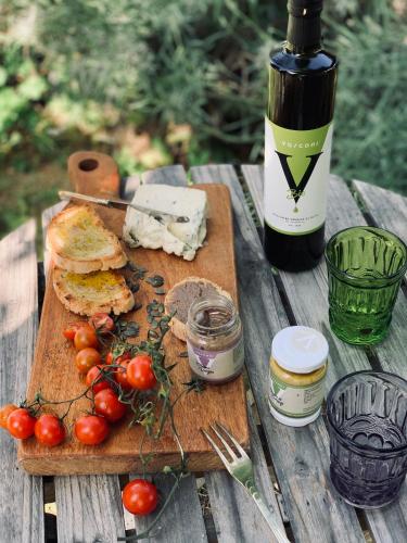 a wooden table with a bottle of wine and tomatoes at Relais B&B Betty Bike in Sassofeltrio