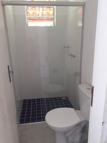 a bathroom with a toilet and a glass shower at Chalés Paradise - Casal in Serra do Cipo