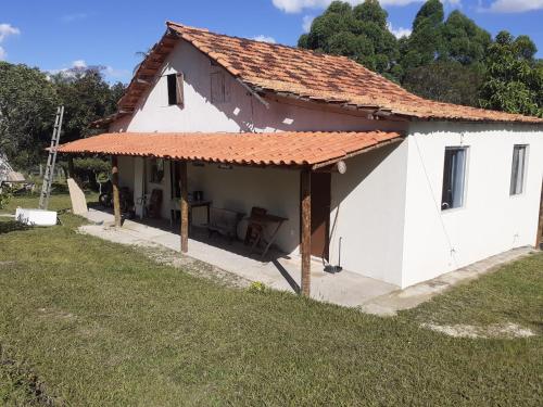 a small white house with an orange roof at Chalés Paradise - Casal in Serra do Cipo