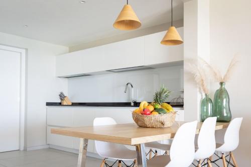 a kitchen with a wooden table with a basket of fruit at Eden Roc Villas in Le Diamant