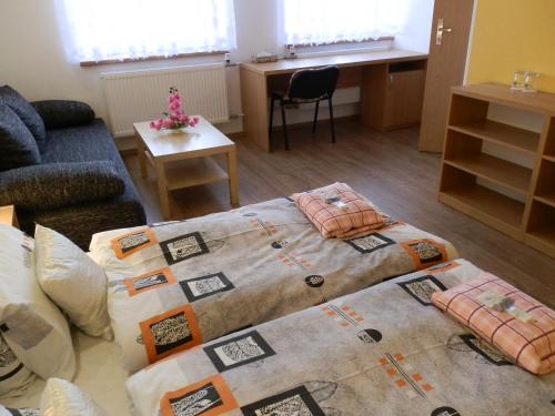 a living room with two beds and a couch at Hotel Gól Prostějov in Prostějov