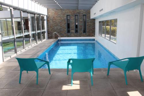 a swimming pool with two chairs and a table at Brava P14 - 1 dorm. (sin sabanas y sin toallas) in Punta del Este