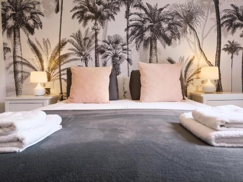 a bedroom with a large bed with palm trees on the wall at Sherryflat San Agustín in Jerez de la Frontera