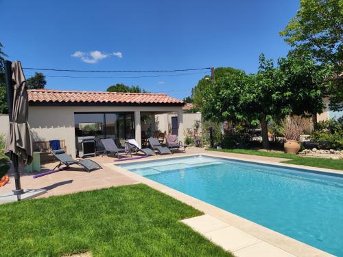 une piscine devant une maison dans l'établissement La Maison des Romarins Chambres Cosy Climatisées Piscine Cuisine, à Aigremont