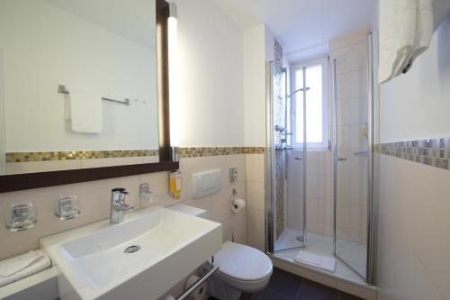 a bathroom with a sink and a toilet and a shower at Best Western Hotel Kaiserhof in Bonn