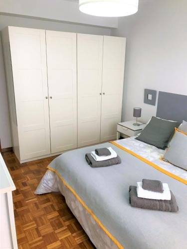 - une chambre avec un grand lit et des serviettes dans l'établissement Tranquilidad al lado del Centro Parking incluido, à Oviedo