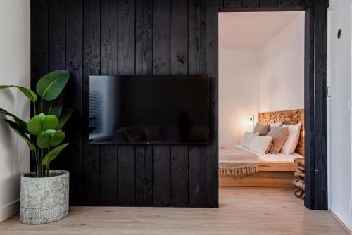 Una sala de estar con televisión en un dormitorio. en Marley’s Beachhouse - Luxury Apartment with garden, en Zandvoort