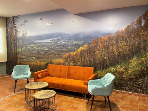 a living room with a couch and a mountain mural at Hostal EL GRIEL NO DISPONEMOS DE RECEPCIÓN FÍSICA in Hervás