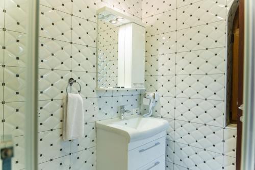 La salle de bains est pourvue d'un lavabo et d'un miroir. dans l'établissement Hotel Camp Karagaq, à Peje
