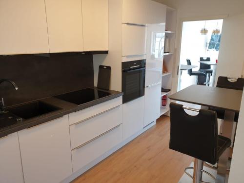 a kitchen with white cabinets and a black counter top at Wundervolle Aussicht in bester Lage auf "Wolke7" in Stromberg