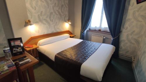 Un pat sau paturi într-o cameră la Hotel Angleterre