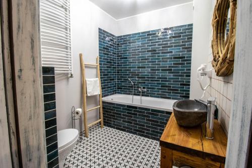 La salle de bains est pourvue de carrelage bleu, d'une baignoire et d'un lavabo. dans l'établissement Apartament Starówka 10 (Miodova), à Toruń