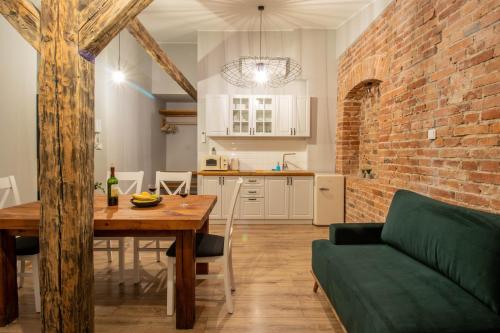 a kitchen and dining room with a table and a brick wall at Apartament Starówka 10 (Miodova) in Toruń