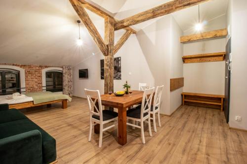 a living room with a wooden table and chairs at Apartament Starówka 10 (Miodova) in Toruń
