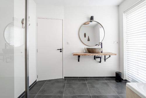 uma casa de banho com um espelho e uma cabina de duche ao nível do chão em Marley’s Beachhouse - Luxury Guest Room with balcony em Zandvoort