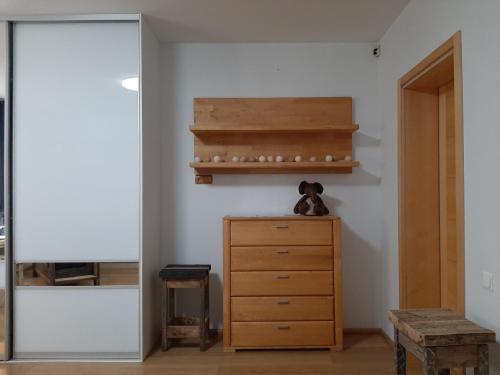 a room with a wooden dresser and a shelf at Champêtre Park View Apartments in Rīga
