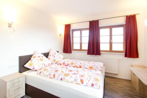 a bedroom with a bed and a window with red curtains at Gasthaus Paulus in Neustadt an der Donau