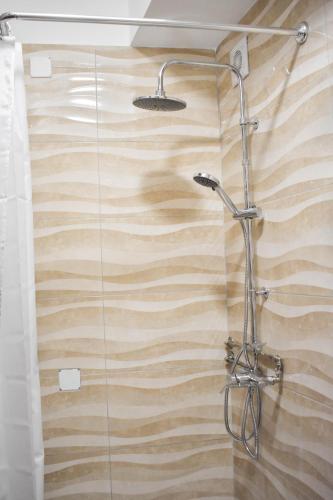a shower in a bathroom with a wooden wall at Batalhoz House II in Cartaxo