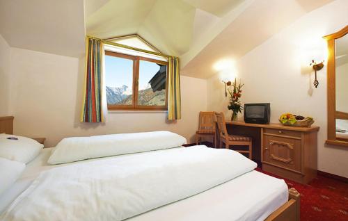 ホッホフィルツェンにあるWarmingerhofのベッド2台と机と窓のある寝室