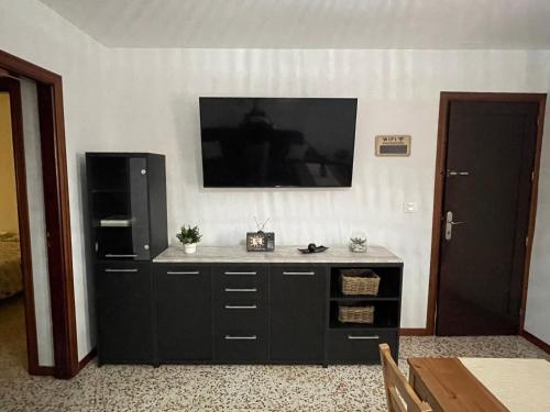 un gran armario negro con TV en la pared en Casa Candelaria, en La Laguna
