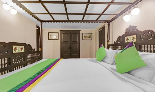 a bedroom with a large bed with green pillows at Treebo Anchor Inn in Cochin