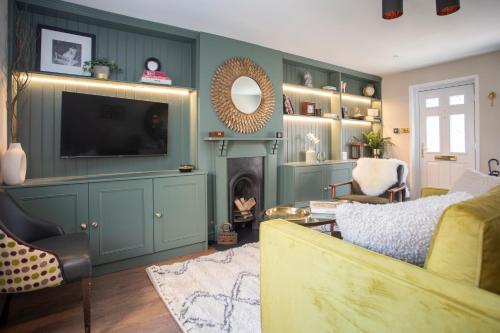 a living room with a tv and a couch and a fireplace at Luxury Townhouse - close to castle & town - perfect stylish stay, sunny private courtyard, dog friendly in Warwick