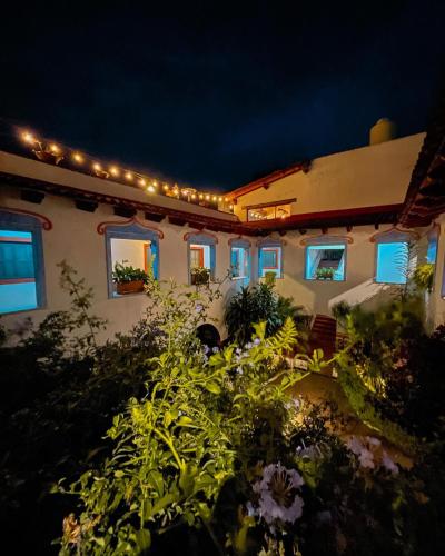 a house with lights on the side of it at night at La Casona Azul Boutique Hotel in Malinalco