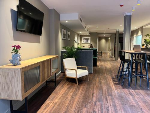 a lobby with a waiting area with a tv and chairs at VTZ Hotel San Valero in Zaragoza