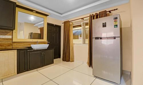 a kitchen with a refrigerator and a sink at Treebo Anchor Inn in Cochin