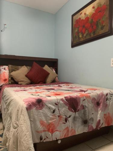 a bedroom with a bed with a floral bedspread at The Insight room is well-appointed in Pawtucket