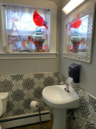 a bathroom with a red bird sitting on a window at The Insight room is well-appointed in Pawtucket