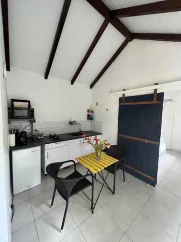 Una cocina con una mesa y sillas en una habitación. en Prune Café, en Deshaies