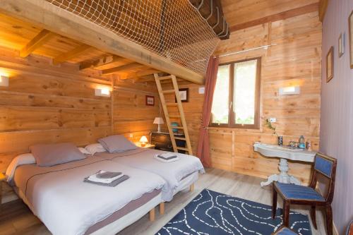 1 dormitorio con 1 cama y lavamanos en una cabaña de madera en Au Milieu de Nulle Part, Chambres et gites écologiques au lac du Der, en Outines