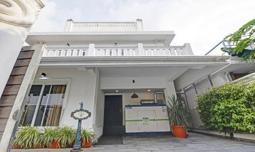een wit huis met een veranda en een garage bij Treebo Trend Anchor Inn in Cochin