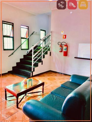 a living room with a couch and a table and stairs at Anexo - Hospedagens Imigrantes in São Pedro