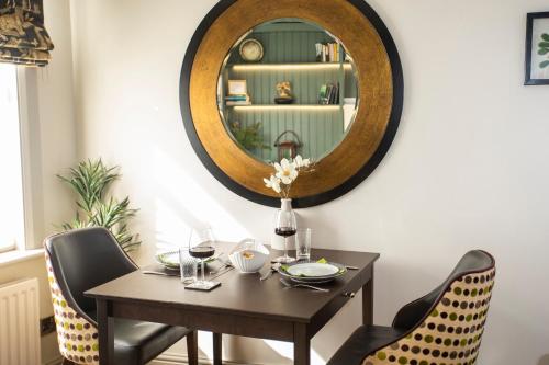 uma sala de jantar com uma mesa e um espelho em Beautiful Boutique Townhouse - 5 mins walk from Warwick Castle & town em Warwick