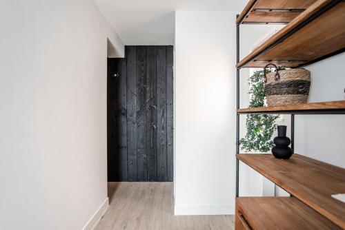 a hallway with white walls and wood floors at Marley’s Beachhouse - Luxury Guest Room with balcony in Zandvoort
