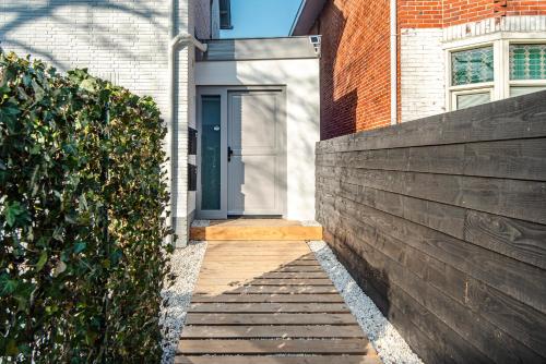 a house with a blue door and a brick wall at Marley’s Beachhouse - Luxury Guest Room with balcony in Zandvoort